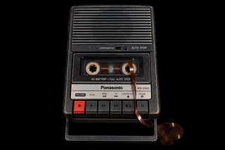 A Panasonic portable cassette recorder, tape unspooling out of the deck